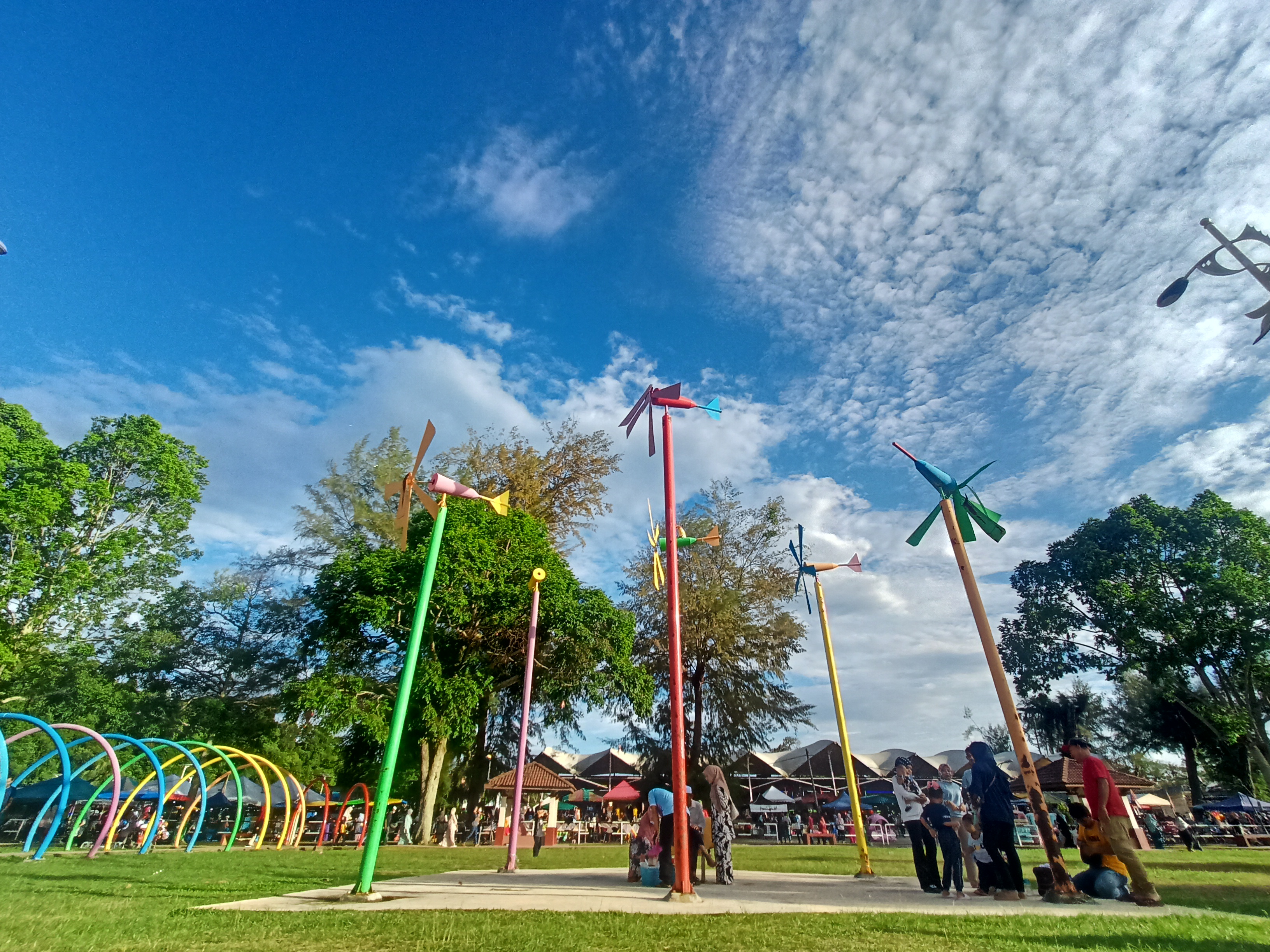 Pemandangan luas pesisir Pantai Merdeka dengan langit cerah dan hamparan pasir