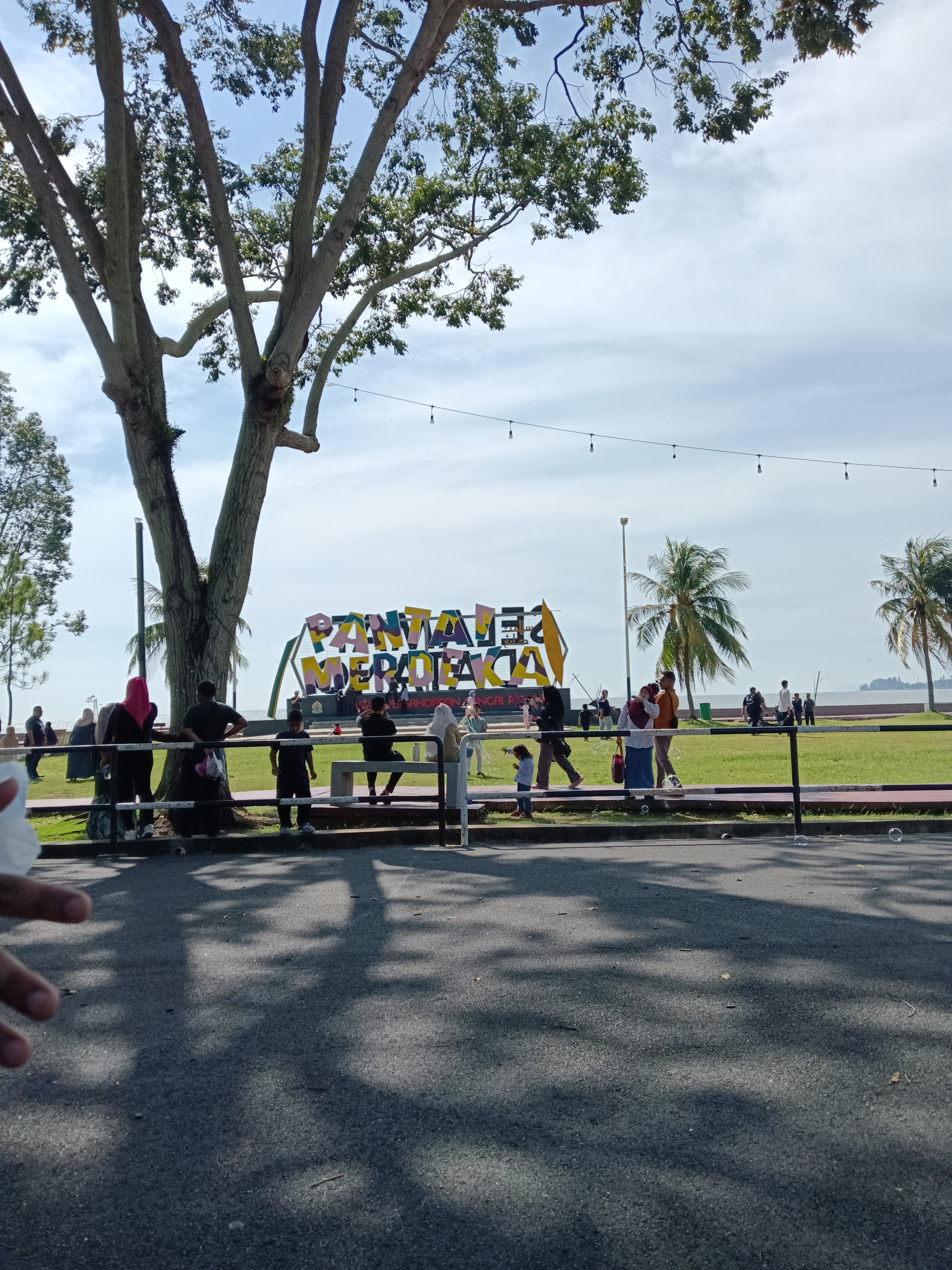 Langit petang berwarna jingga kebiruan di atas permukaan Pantai Merdeka